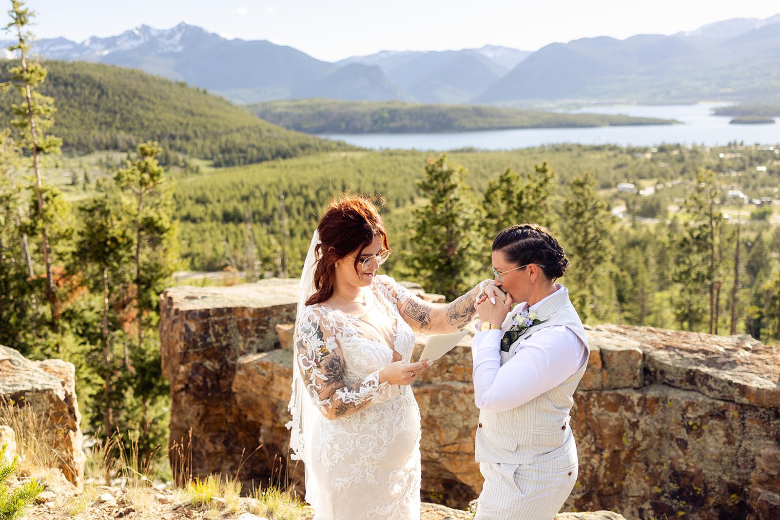 bride kissing brides hand during  Summit County Elopement at sunset in Colorado 
