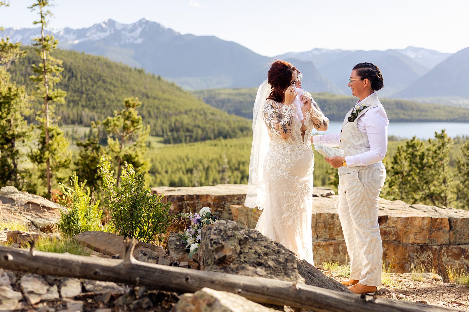 bride wiping tears wearing white gown at  Summit County Elopement in Colorado. 