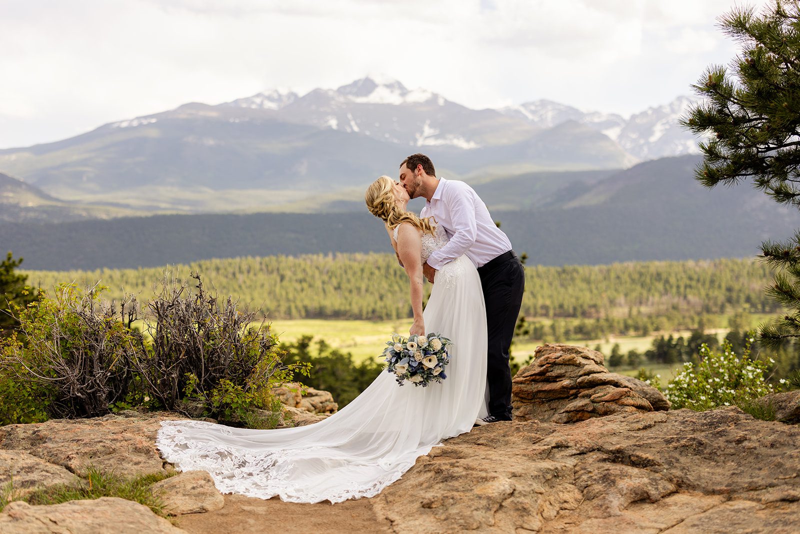 bride and groom kissing in Rocky Mountain National Park after Summer elopement at 3M curve.