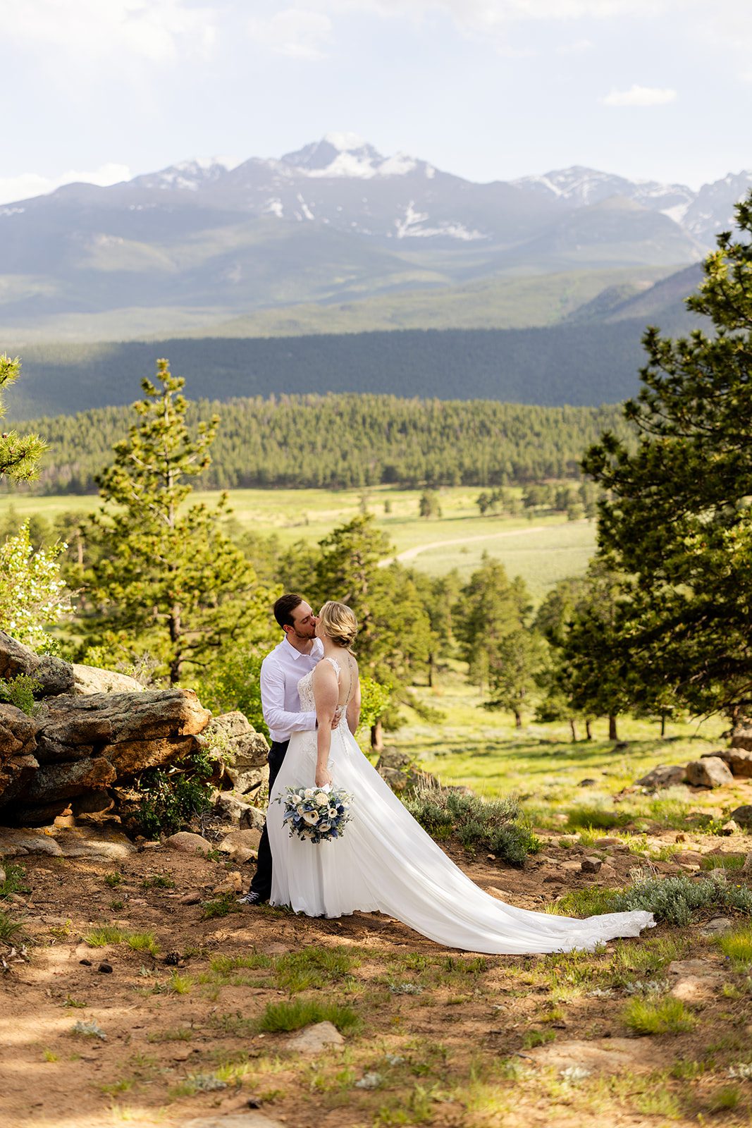bride and groom kissing in rocky mountain national park after their bride and her bouquet after her elopement.