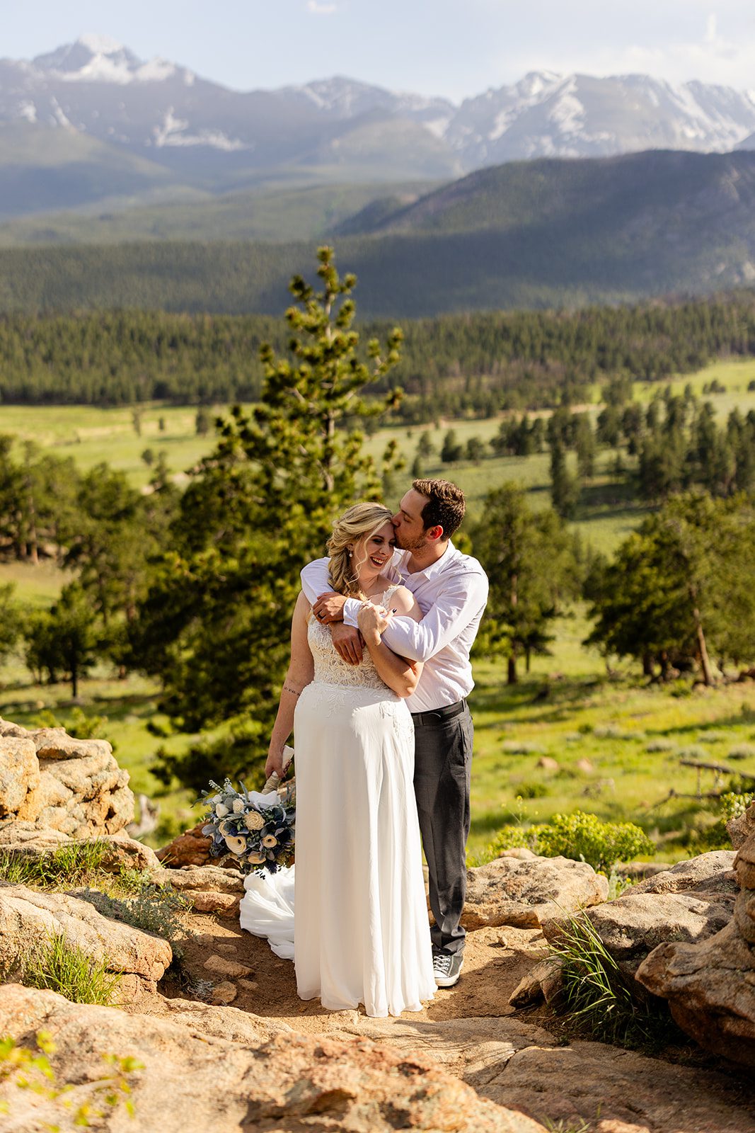 groom kisses bride forehead in rocky mountain national park after their summer elopement ceremony at 3m curve.