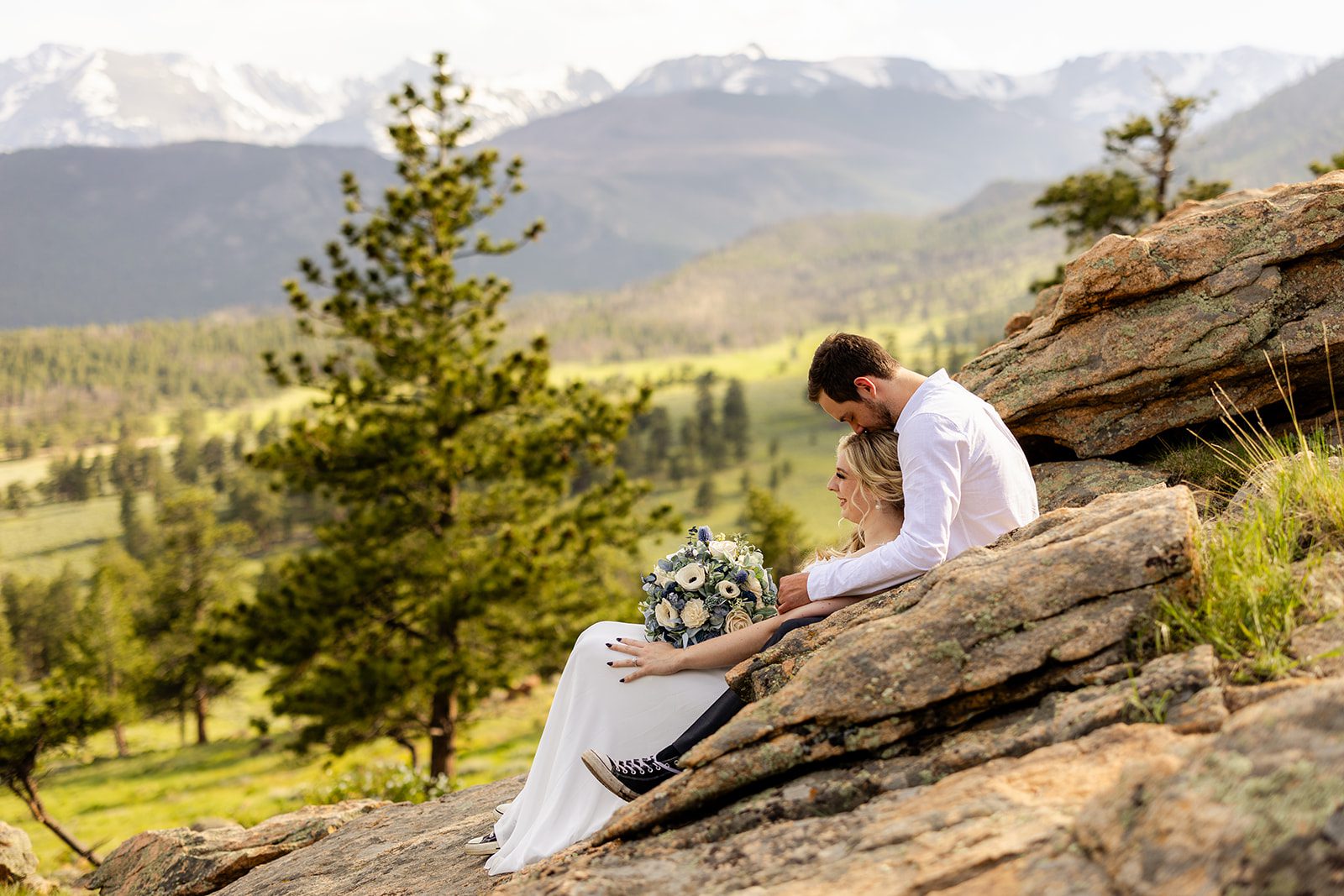 groom kisses bride on the forehead, in rocky mountain national park.