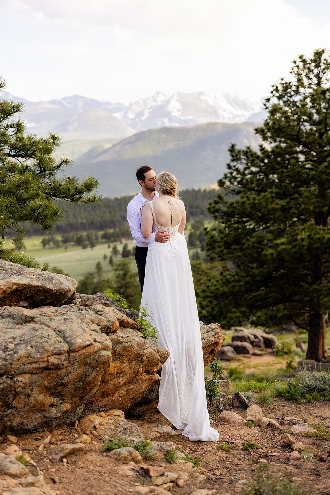 bride and groom holding each other in rocky mountain national park after their summer elopement ceremony at 3m curve.