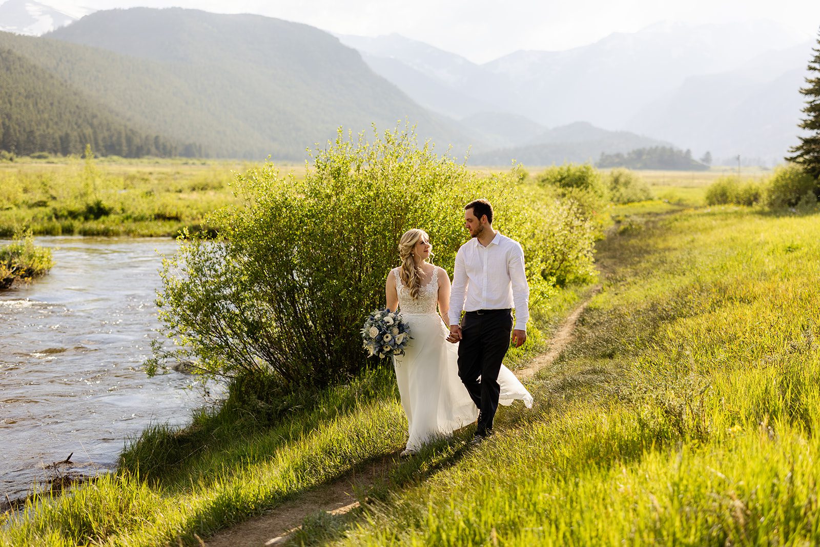 bride and groom walking by mountain lake after Summer Elopement ceremony at 3M Curve