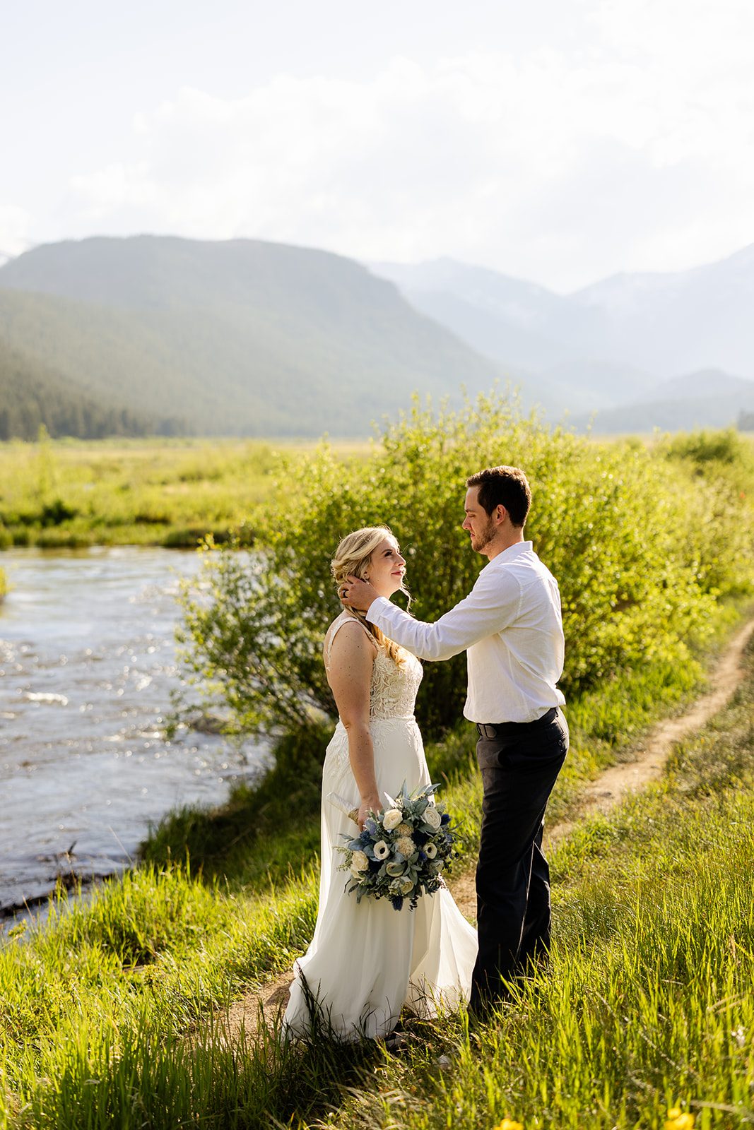 bride and groom smiling at each other near lake in 3m curve after their summer elopement.