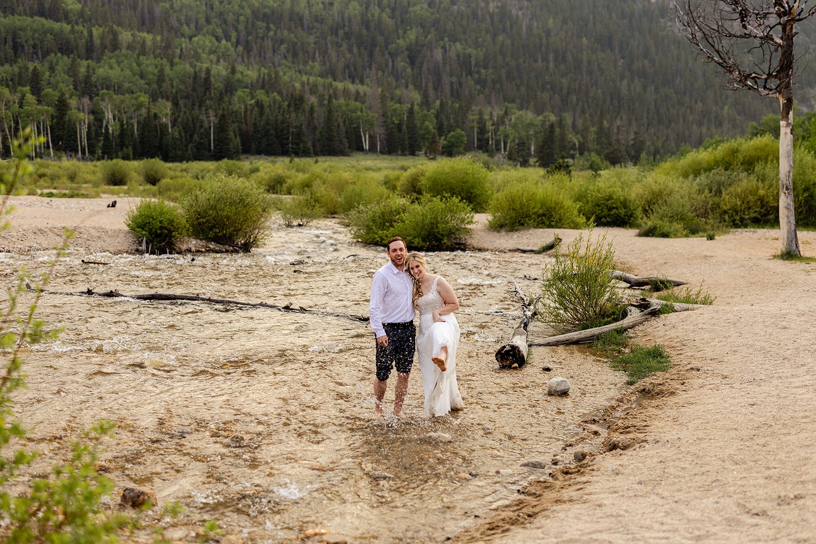 bride and groom take a dip after 3m curve elopement at alluvial Fan Bridge & Waterfall