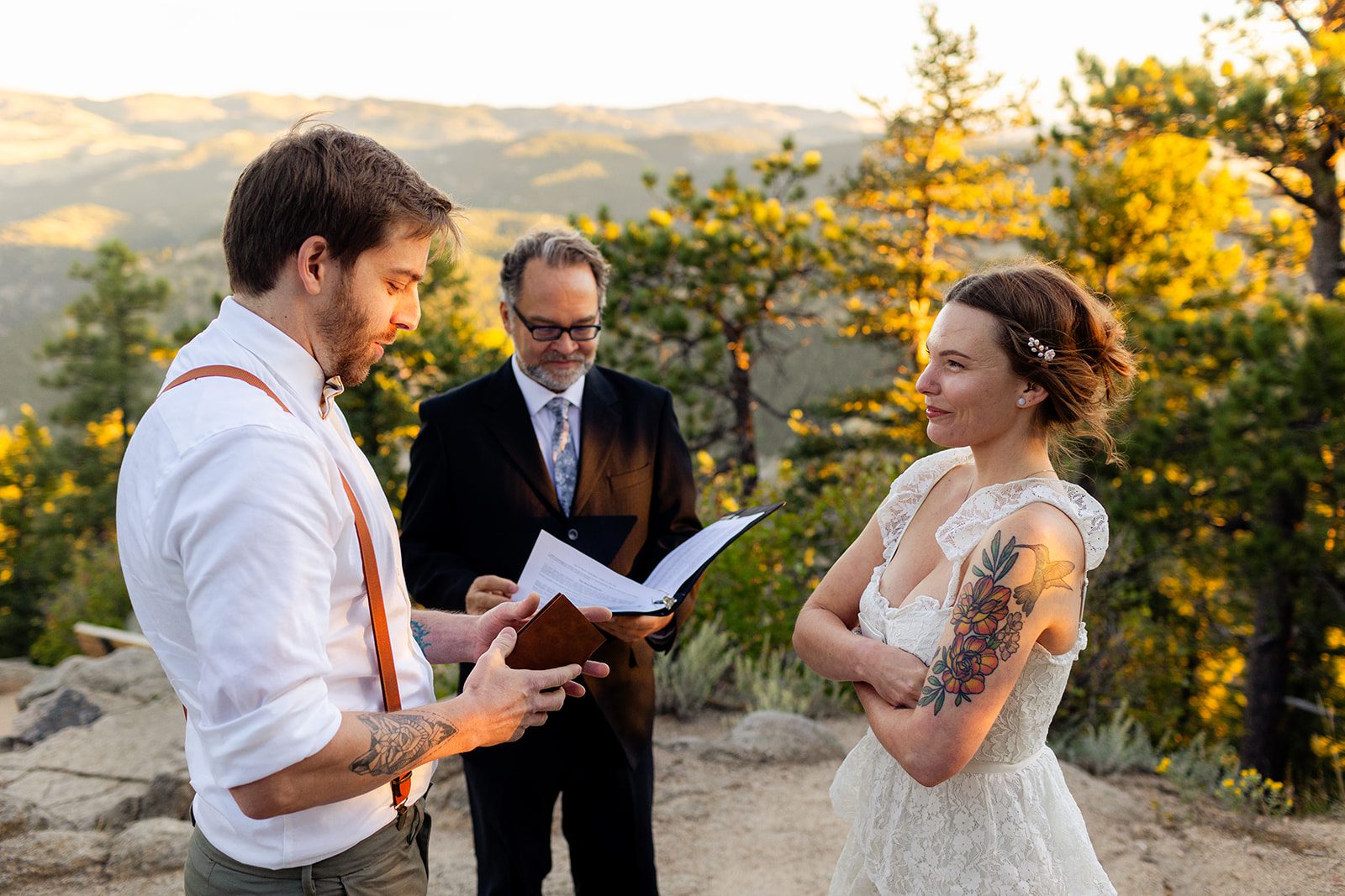 bride listens to groom read his vows during elopement ceremony in Colorado at sunrise