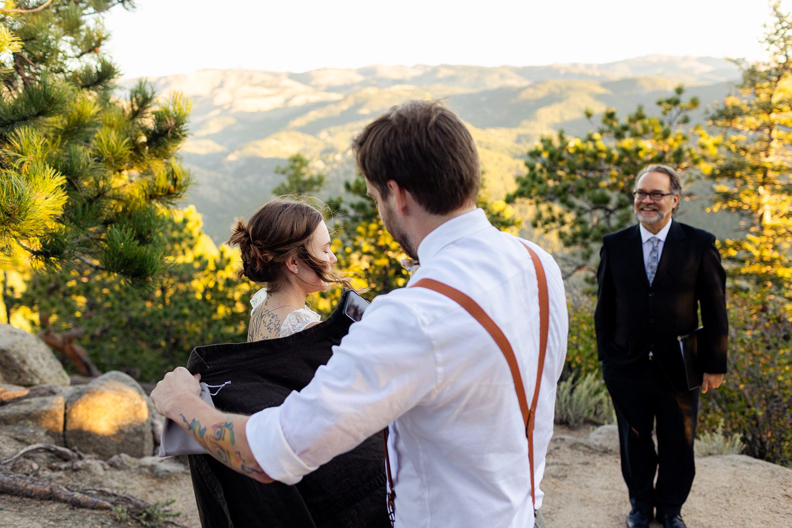 groom puts jacket on bride after elopement ceremony at artist point 