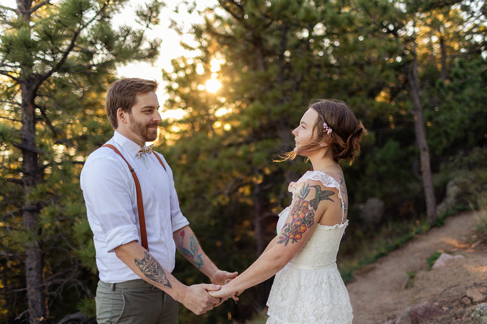 bride and groom holding hands and smiling at each other at Artist Point at sunrise. 