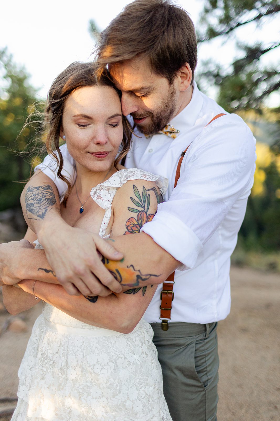groom and bride hug, tattooed couple after sunrise elopement at artist point