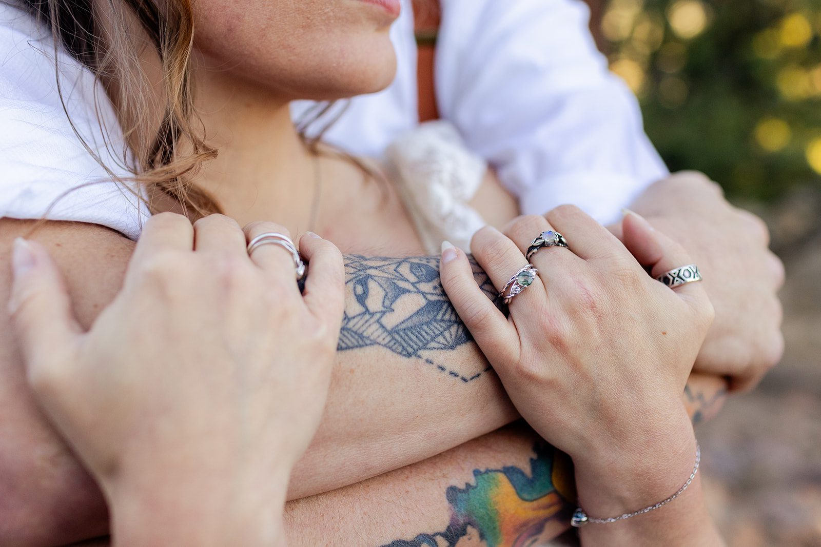 close up of rings, tattooed bride and groom