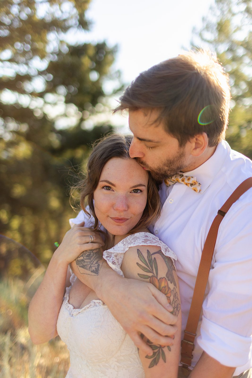 close up of beautiful bride. groom in suspenders, cuddling close after sunrise elopement at Artist Point.