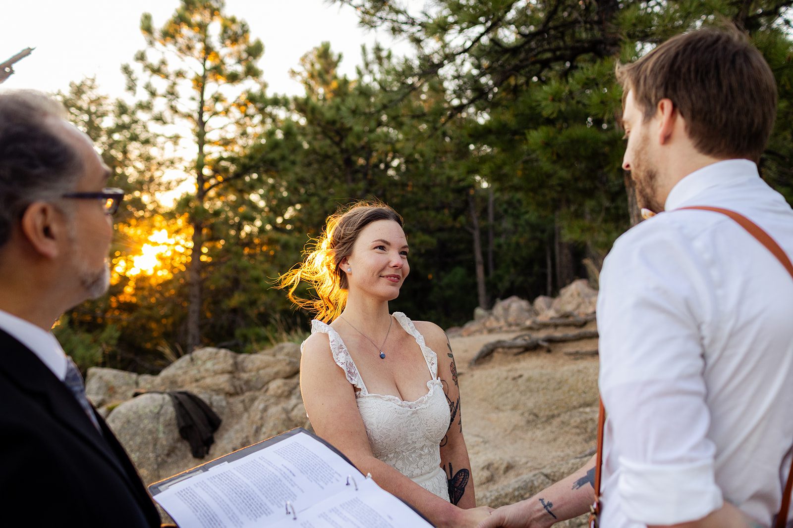 bride looks sweetly at her groom while he reads his vows during their Sunrise Elopement at Artist Point