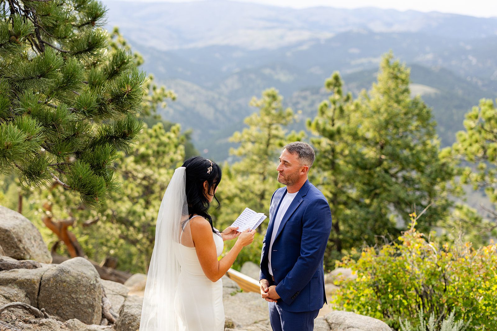 Groom listening to bride reading vows during elopement Artist Point ceremony