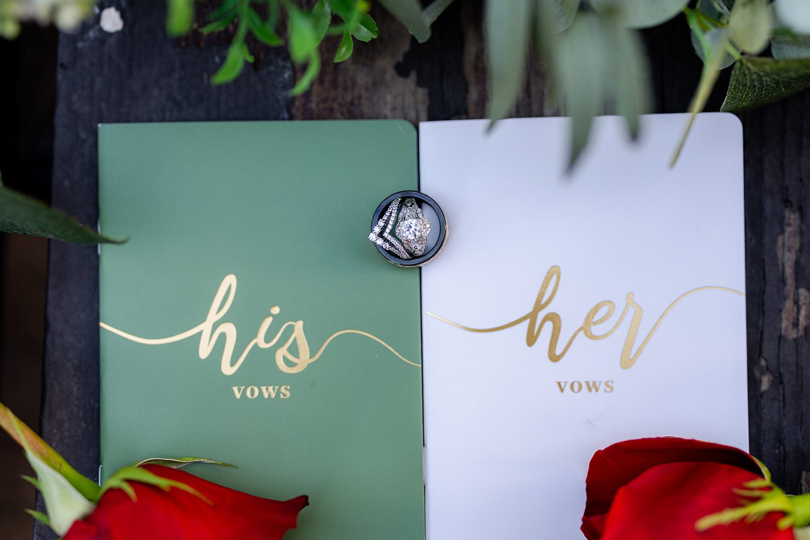His and hers vow books with wedding rings and red roses from rose ceremony for eloepment. 