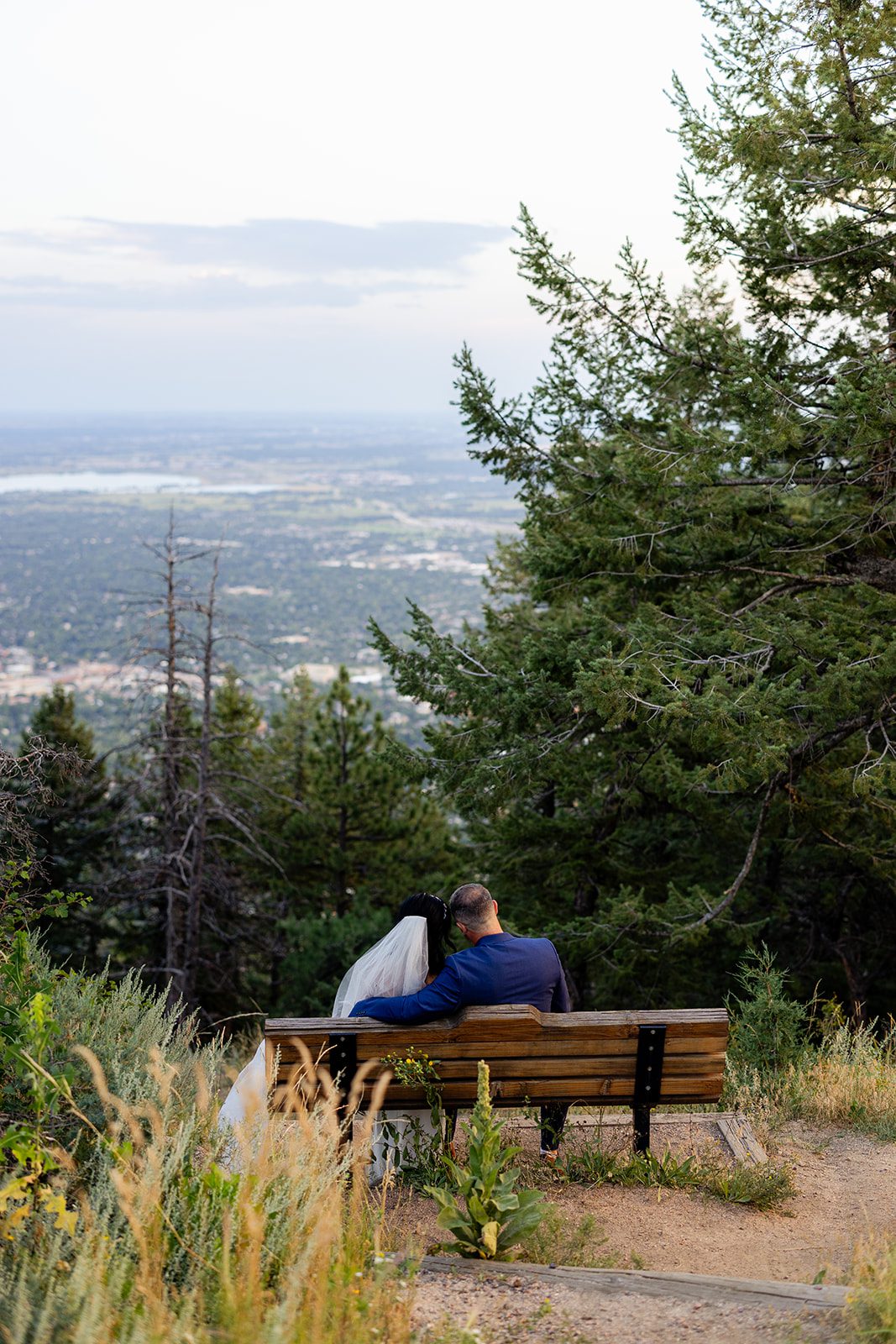 bride and groom soaking in the their Sunset Elopement at Artist Point on a bench overlooking boulder, colorado. 