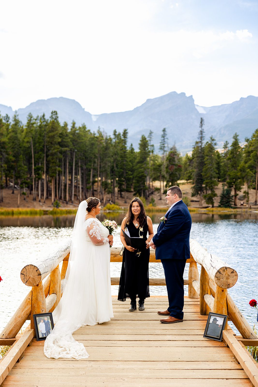bride and groom with officiant, standing on the dock for their Fall elopement ceremony at Sprague Lake. 