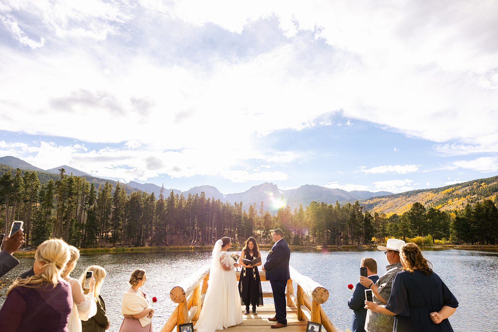 bride and groom with guests during Fall elopement ceremony at Sprague Lake. 