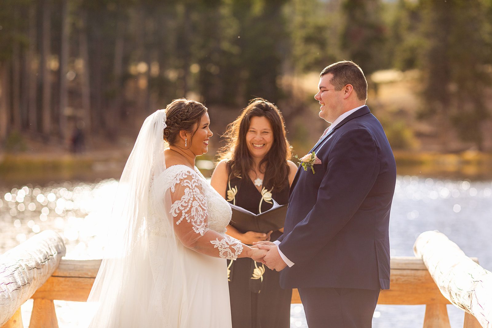 bride and groom smiling at each other, holding hands during their Fall elopement ceremony at Sprague Lake. 