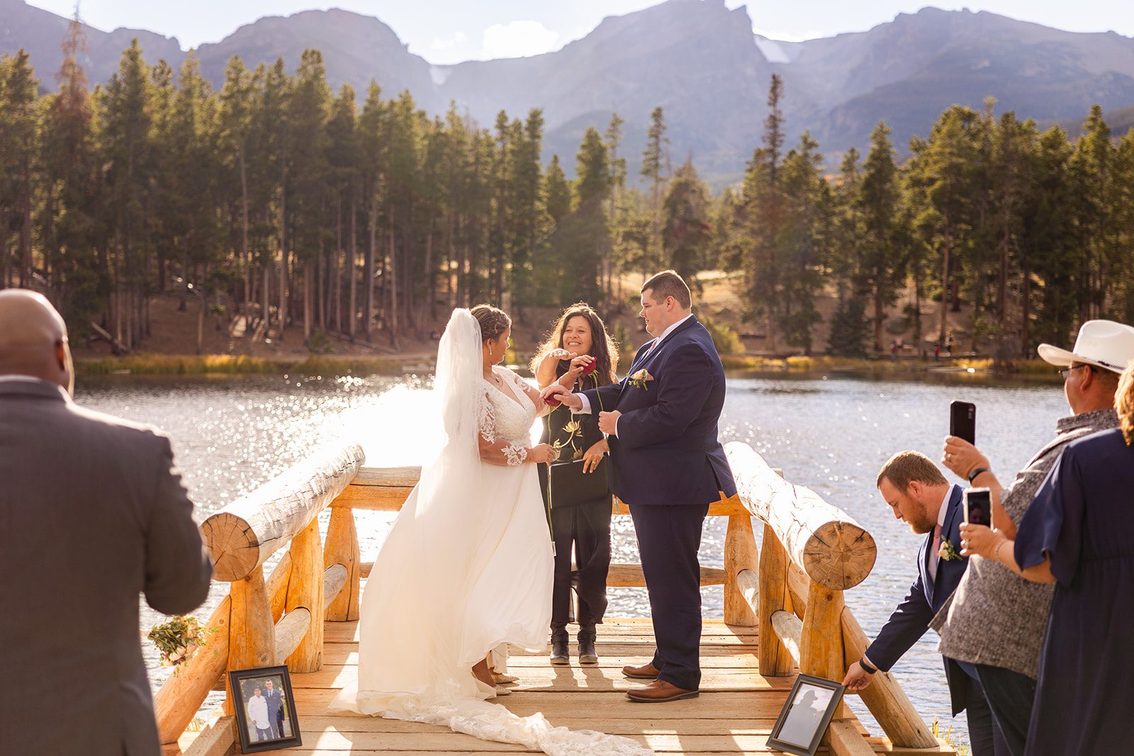 bride and groom exchange roses during Fall elopement ceremony at Sprague Lake. 