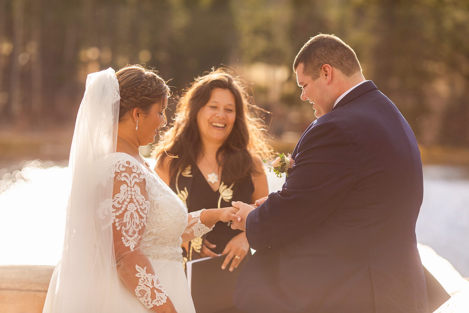 groom slides ring no his brides finger during Fall elopement ceremony at Sprague Lake. 