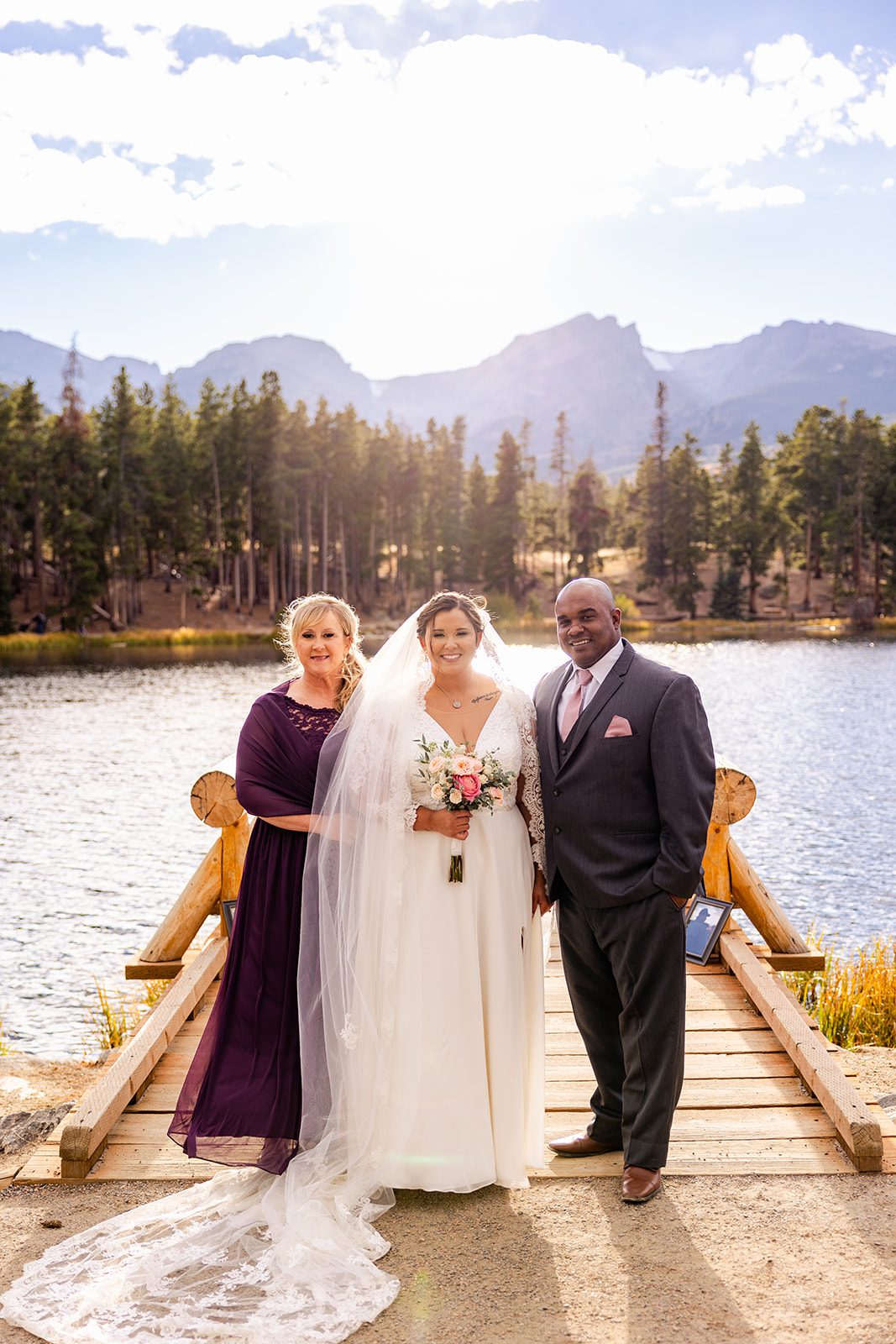 bride in white wedding dress with her parents after her Fall elopement at Sprague Lake