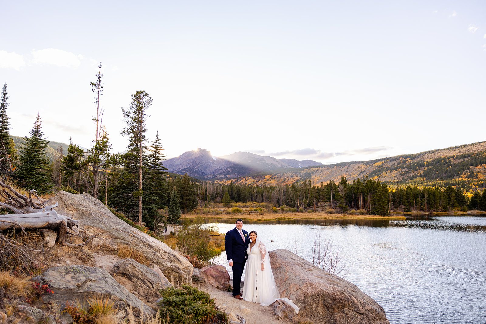 Bride and groom smiling after their Fall elopement at Sprague Lake in Rocky Mountain National Park. 