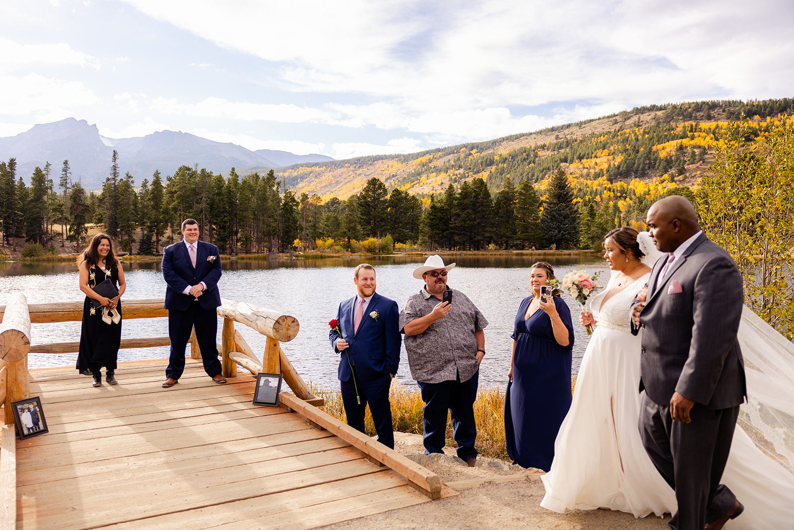 Bride walking with her father down the aisle towards her groom for their fall elopement at Sprague Lake. 