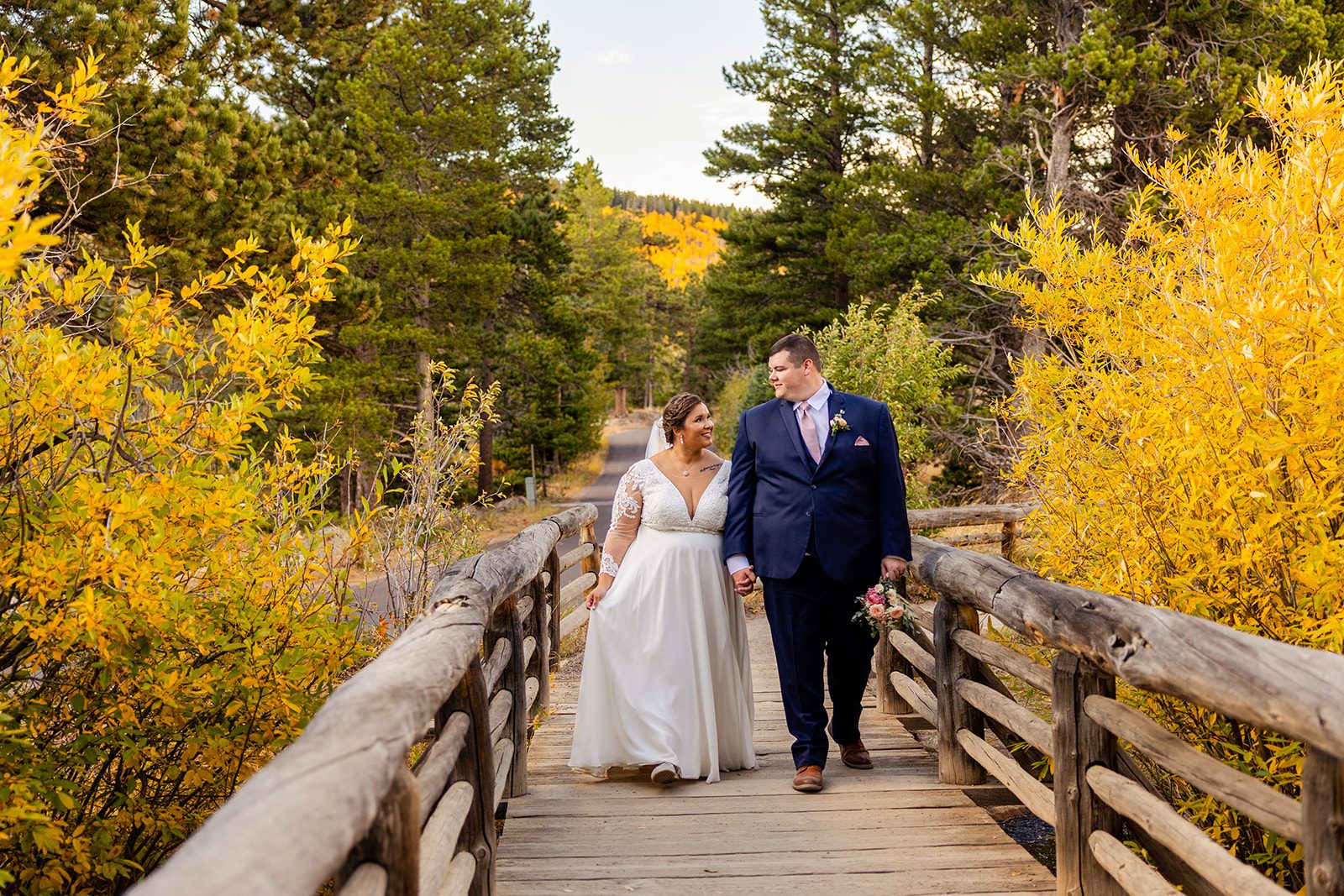 bride and groom holding hands, walking together after Fall elopement at Sprague Lake