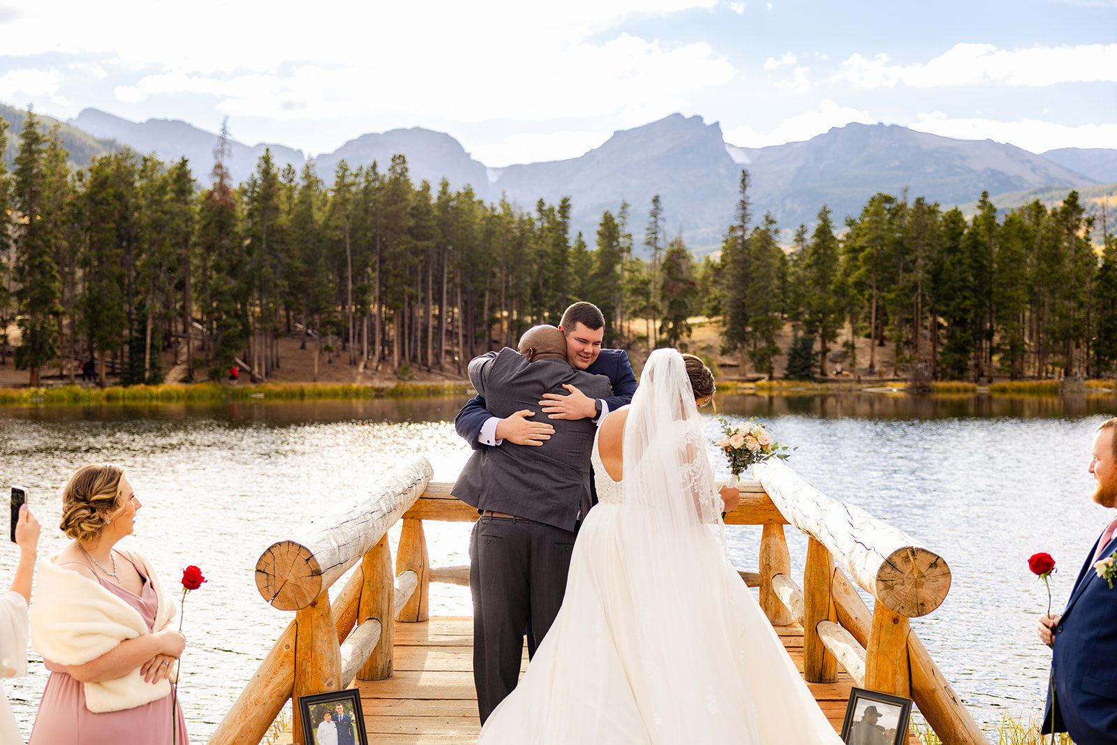 groom hugs father of the bride before their Fall elopement ceremony begins  at Sprague Lake. 