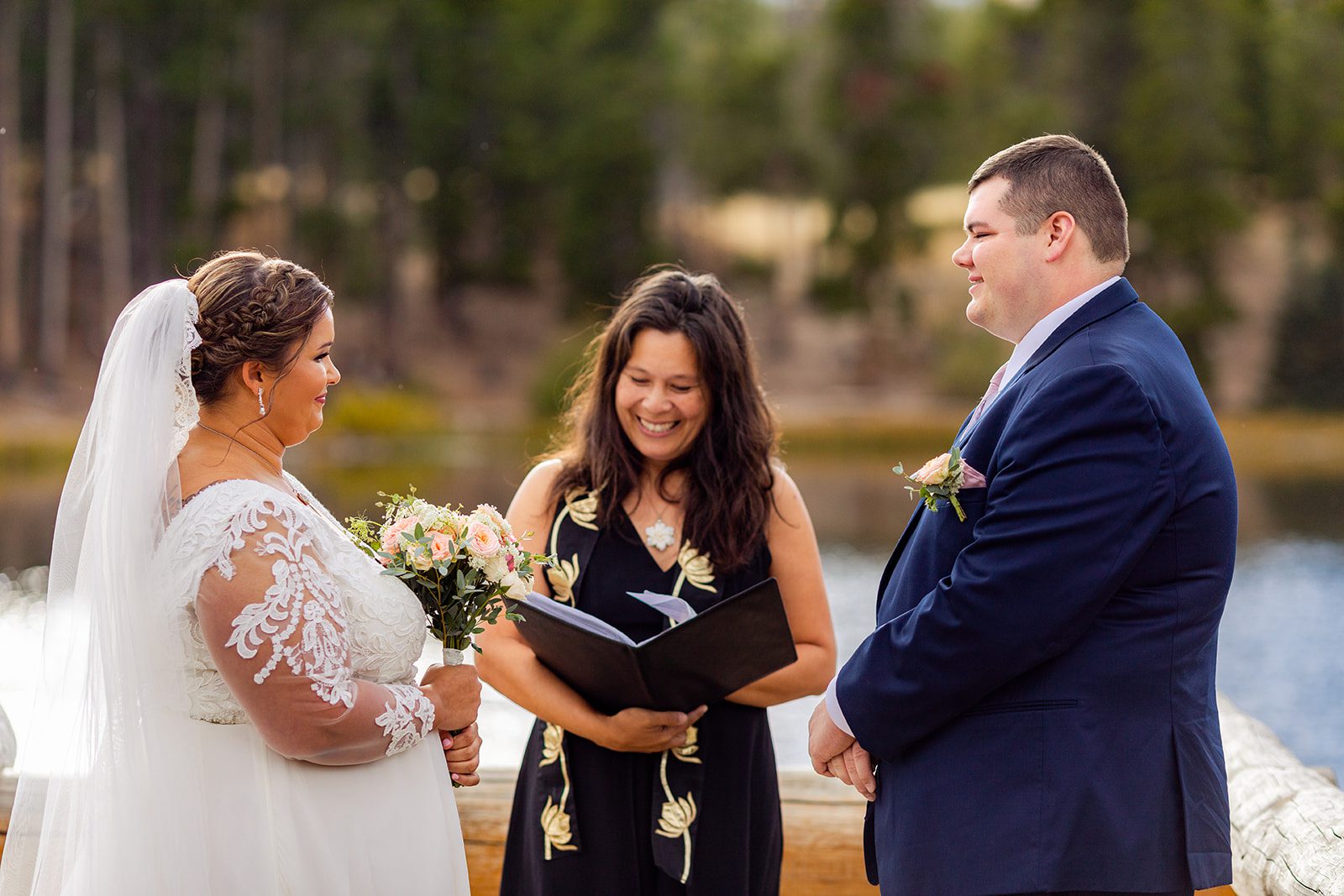 bride and groom smiling at each other as officiant leads them though their Fall elopement ceremony at Sprague Lake. 